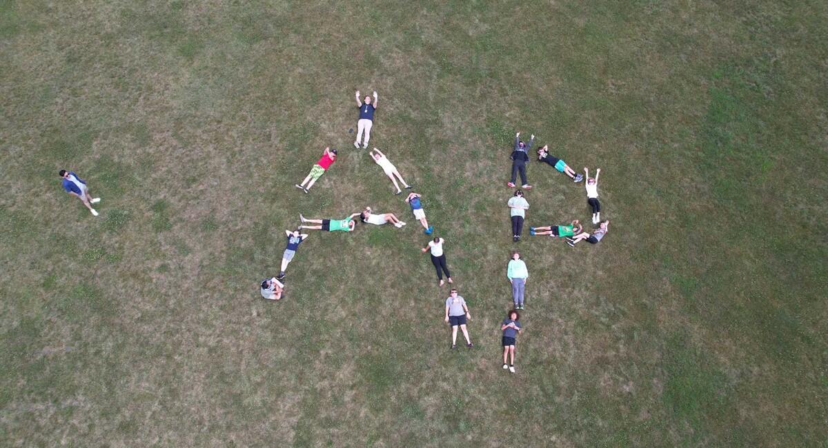 Spelling out the school initials on a grassy area